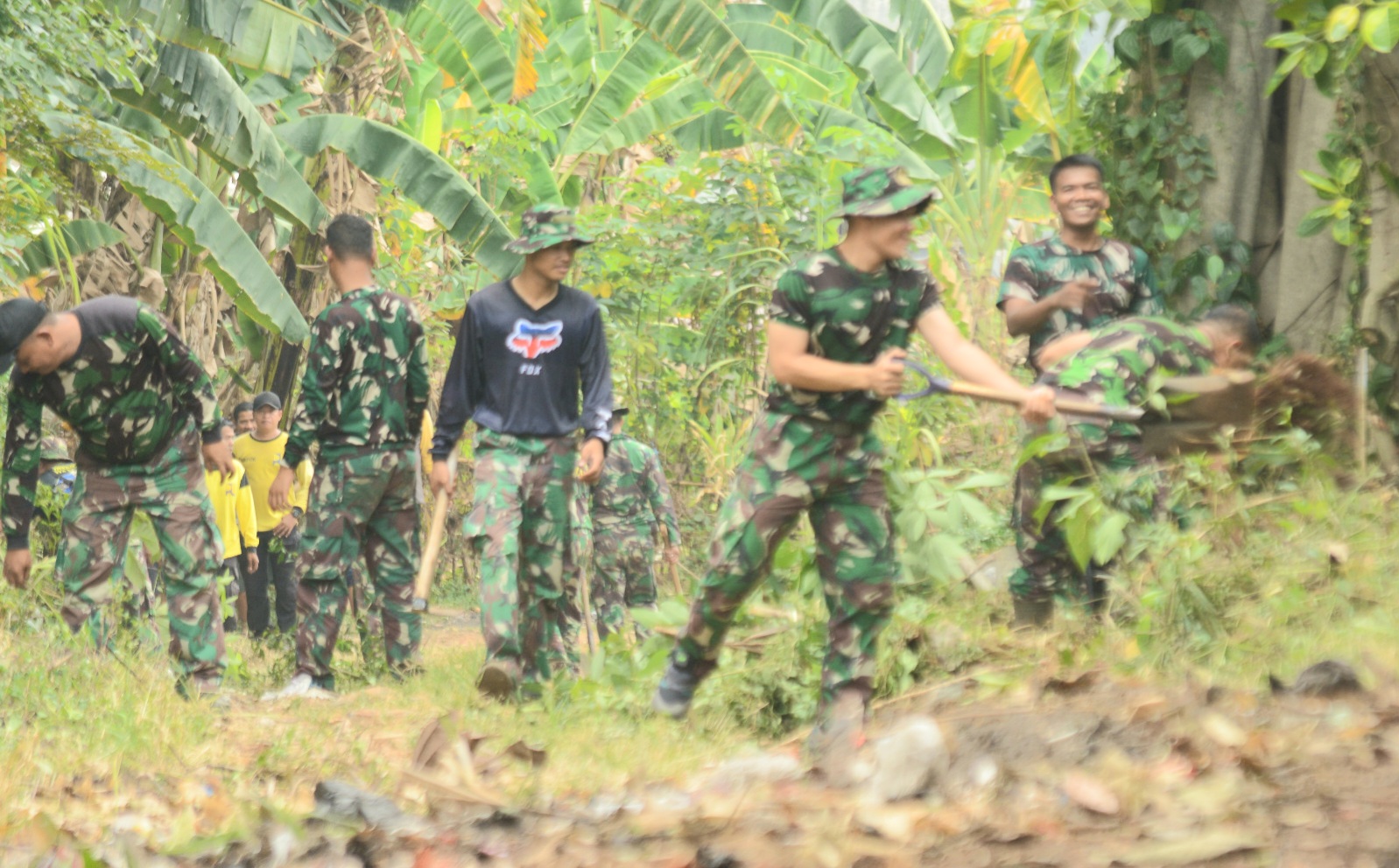 Satgas TMMD Kodim Depok melakukan land clearing di jalan yang akan dibetonisasi, di RT 03 RW 13 Kelurahan Rangkapan Jaya. (Foto: Ari Pandim Depok)